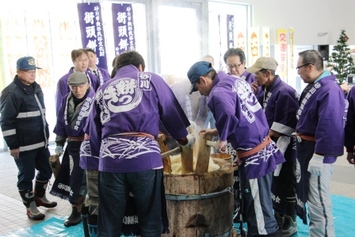 参加者の方々が餅つきをしている様子