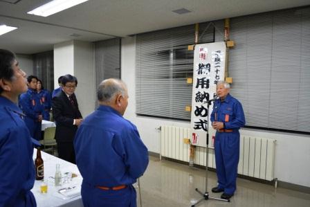 砂川消防団の御用納め式にて堀団長が隊員の方々の前で挨拶をしている様子