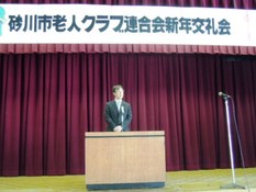 砂川市議会飯澤議長が壇上にて挨拶している様子