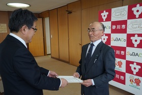 砂川市長から谷口委員に選任書を手渡しているところ